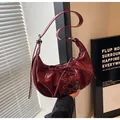 Bolso de hombro media luna en charol rojo oscuro con detalles de cordones cruzados - Rojo
