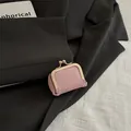 Pink lychee grain leather kiss-lock mini purse with gold metal clasp on a blazer - Pink
