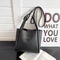 Elegante schwarze Tote Bag aus Leder mit goldener Aufschrift und verstellbarem Riemen - Schwarz