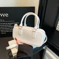 Elegante borsa Boston bianca minimalista con doppi manici e finiture dorate lucide - Bianco