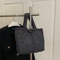 Black heart-quilted large tote bag with padded nylon texture and drawstring detail - Black