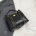 Bolso bandolera acolchado negro con cadenas doradas y cierre de giro elegante - Negro