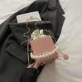 Pink woven bucket bag with pearl handle, gold chain strap, and drawstring inner bag - Pink