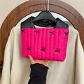 Gesteppte rosarote Handtasche mit schwarzen Schleifenstickereien und Ledergriff im Design - Fuchsia