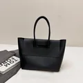 Minimalist matte black leather tote bag with flap closure and slim top handles - Black