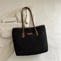 Minimalistische schwarze Nylon-Tragetasche mit braunem Lederbesatz und Schulterriemen - Schwarz und Braun