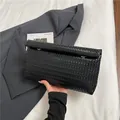 Minimalistische schwarze gewebte Leder-Clutch mit goldener Hardware für Damen - Schwarz