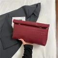 Dunkelrote Clutch aus geflochtenem Leder mit goldenen Ringen und großem Fassungsvermögen - Rot