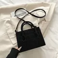 Bolso bandolera negro con textura de leopardo, asas superiores y diseño minimalista - Negro