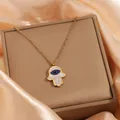 Détail du collier main de Hamsa doré avec cristaux bleus et blancs sur soie - Collier Zircone en Forme d'Œil