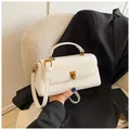 Close-up of white minimalist square handbag with gold hardware and smooth leather finish - White