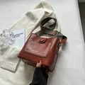 Brown leather bucket bag with vintage studs and colorful ethnic bohemian shoulder strap - Brown