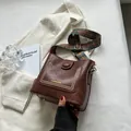 Vintage brown bucket bag with golden studs and a colorful ethnic patterned woven strap - Coffee