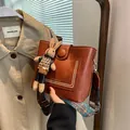Sac seau marron en similicuir avec charm lapin et large bandoulière à motifs - Avec Pendentif / Marron