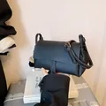 Minibolso bandolera de cuero negro con pespuntes blancos y colgante de pompones - Negro