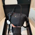Mini borsa in nylon nero con ciondolo a forma di panda e tracolla regolabile su set minimal - Nero