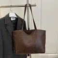 Large dark brown vintage oil leather tote bag for women showing a retro commuter style - Coffee