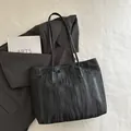 Bolso tote negro minimalista con textura ondulada vertical y asas largas finas - Negro