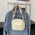 Minimalist cream corduroy crossbody bag shown over a denim jacket for a casual look - Off White