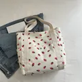 White corduroy strawberry print tote bag with canvas handles and metal snap button closure - White