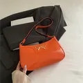 Chic orange faux leather underarm bag with a golden bow metal buckle detail - Orange