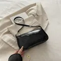 Zwarte lakleren baguette-tas met een minimalistisch ontwerp en een slanke schouderband - Zwart