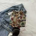 Ethnic style bucket bag with floral embroidery, gold chain strap and pearl accents - Colorful