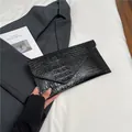 Classic black envelope clutch bag featuring vintage crocodile pattern and minimalist design - Black