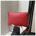 Close-up of red quilted crossbody bag featuring silver stud details and leather texture - Red