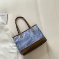 Blue denim tote bag with brown leather handles in a stylish vintage bucket bag design - Blue