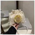 Detail van beige handgeweven strooien emmertas met zonnebloem en katoenen trekkoorden - Wit en Geel