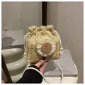 Detail van een geweven strooien emmerzak met een witte madeliefje en trekkoordsluiting - Khaki en Wit
