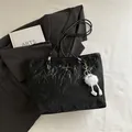 Chic black textured tote bag with elegant thin straps and a cute plush ball charm - Black With Pendant