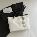 Off-white cloud texture tote bag with black trim and a cute plush monster charm - White With Pendant