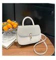 Detail of white handbag featuring a sparkling silver glitter flap and gold horseshoe lock - White