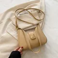 Elegant beige crescent shoulder bag featuring gold pyramid stud hardware and thin strap - Khaki