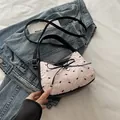 Pink quilted shoulder bag with black bows and heart charm on a casual setting - No Pendant / Pink