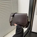Dark brown matte PU leather shoulder bag with a unique wavy flap and golden chain detail - Brown