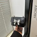 Mini borsa a tracolla nera pitonata con fiocco argentato e catena sottile in metallo - Nero