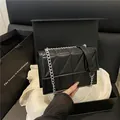 Quilted black leather crossbody bag with silver chain strap shown in a gift box packaging - Black