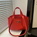 Red matte leather tote bag with silver metal bow and adjustable shoulder strap - Red
