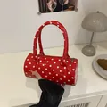 Mini red cylindrical crossbody bag with white polka dots and glossy patent leather finish - Red