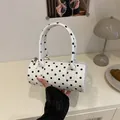 Chic white cylinder handbag with black polka dots featuring top handles and a zipper - White