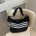 Minimalist black messenger bag with white stripes and adjustable nylon shoulder strap - Black