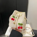 Creamy white woven bucket bag with 3D cherry accents and cotton drawstring closure - Cherry Cream White
