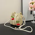 Straw woven bucket bag in beige with red cherry appliqué and white drawstring cord - Cherry Khaki