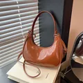 Retro caramel crescent shoulder bag with glossy textured leather and minimalist design - Brown