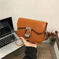Chic brown leather crossbody square bag with a prominent silver geometric buckle detail - Brown