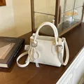 Chic cream-white pebbled leather square bag with pearl lace bow charm and crossbody strap - White