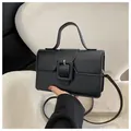 Minimalist black square crossbody bag with large decorative buckle and top handle - Black